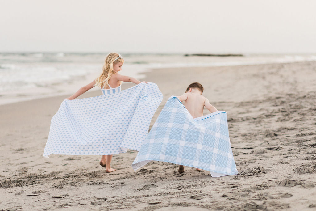 the little palm kids with beach towels on the beach